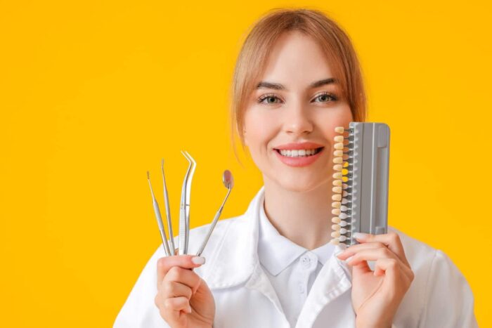 female dentist with tools teeth color chart yellow surface1