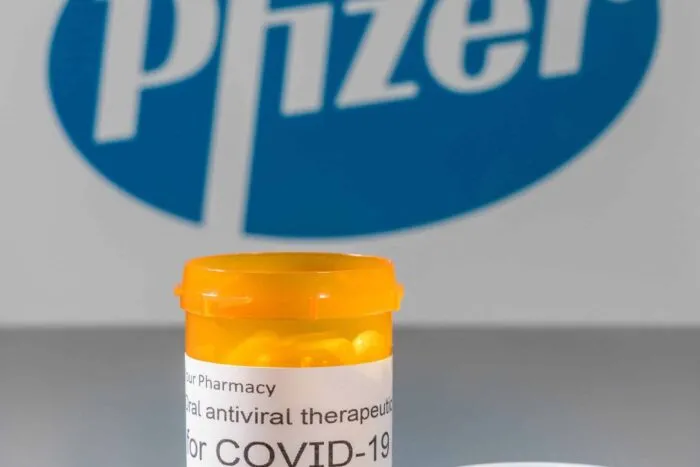 Morgantown, WV - 5 April 2021: Prescription bottle and capsules illustrates Pfizer trials of oral antiviral treatment for SARS-CoV-2 or Covid-19 virus