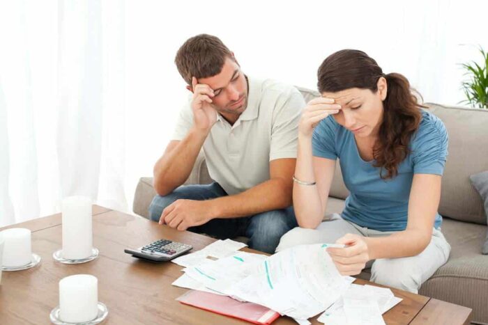Worried,Couple,Doing,Their,Accounts,In,The,Living,Room,At
