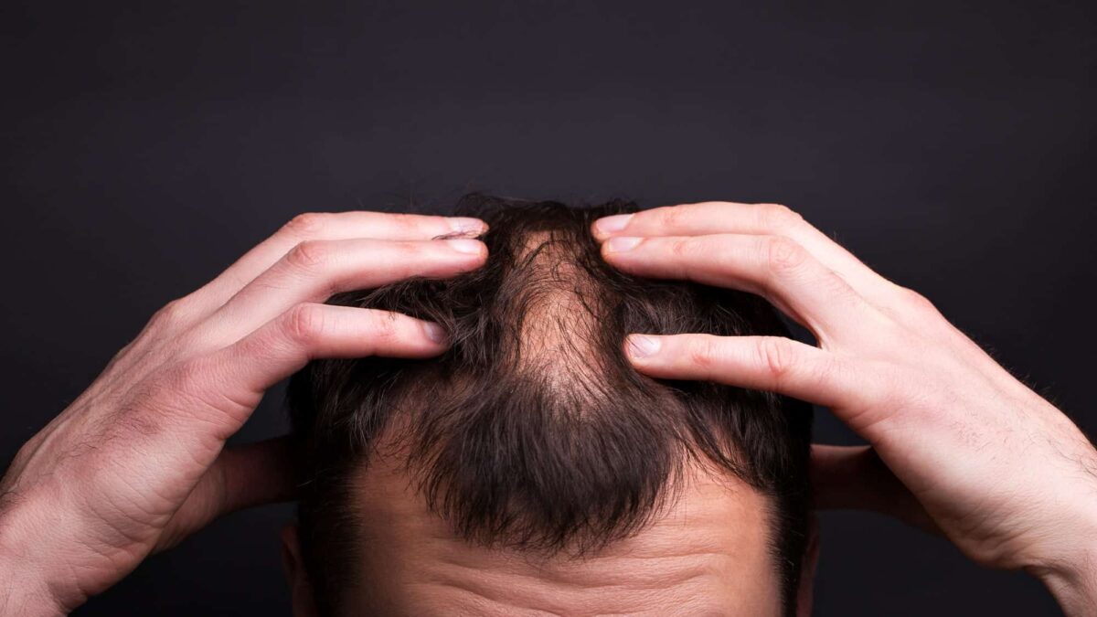 men-with-bald-head-black-wall-close-up