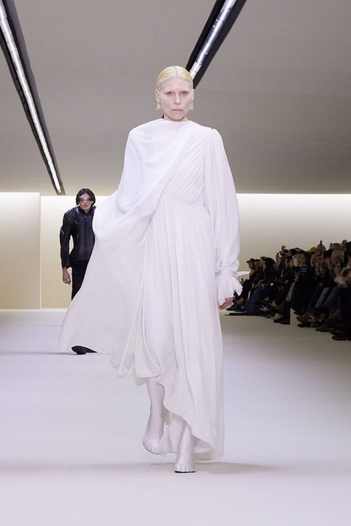 Un model într-o rochie albă fluidă