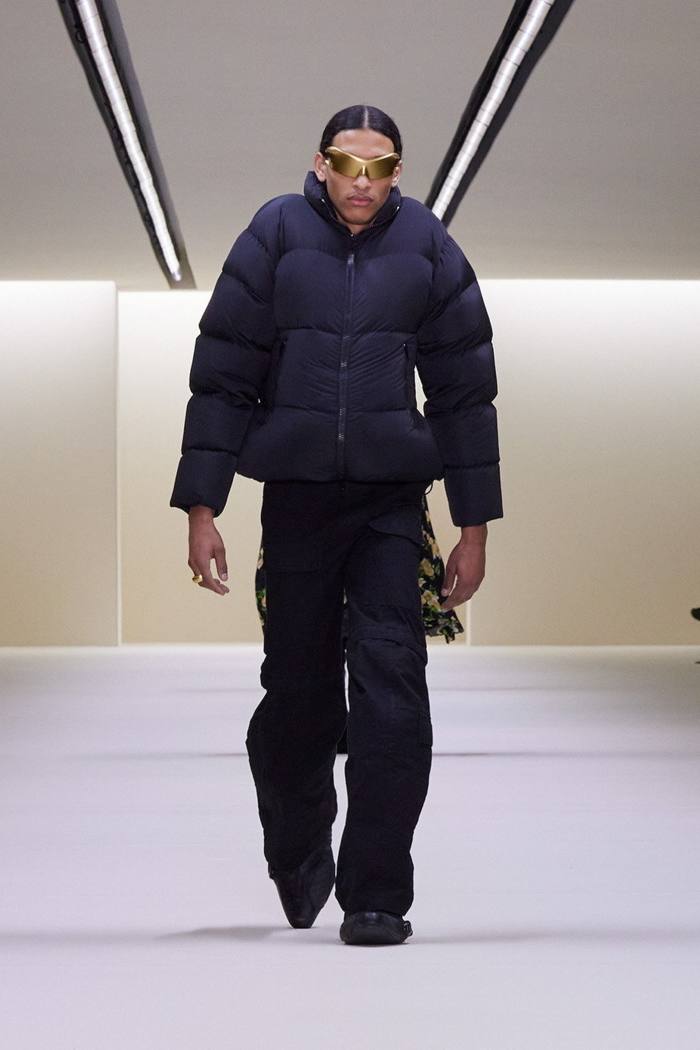 Un model masculin în jachetă căptușită și pantaloni largi