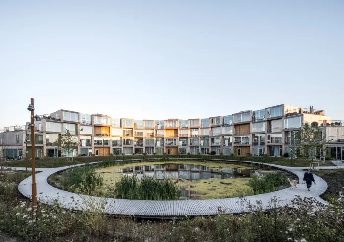 În Danemarca, blocul de apartamente al grupului Bjarke Ingels Sneglehusene se curbe în jurul unui iaz, care funcționează ca colectare a apei de ploaie