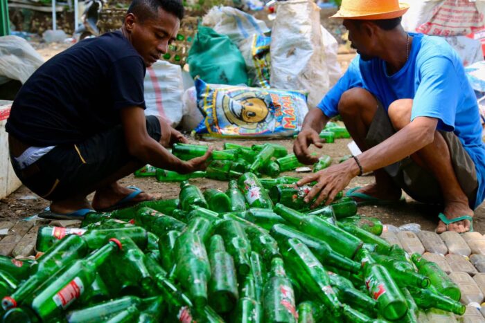 Workers seperate beer bottles at the recycling centre at Nusa Lembongan