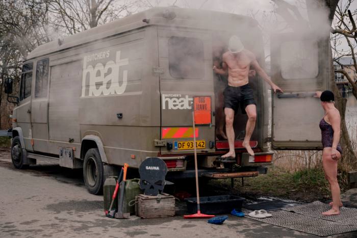 Un bărbat care iese din spatele dubei de saună Butcher's Heat, un fost vehicul militar transformat