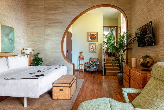 O suită de hotel cu intrare rotunjită în peretele dintre dormitor și zona de relaxare