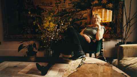 Courtney Love acasă la Londra. Pe peretele din spatele ei este o tapiserie cu verdeață flamandă din secolul al XVII-lea