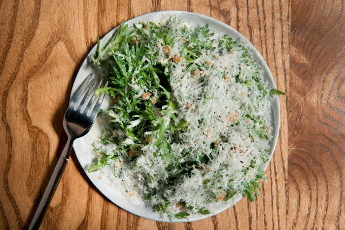 O farfurie cu salată de crizanteme cu usturoi, susan și parmezan la Don Angie