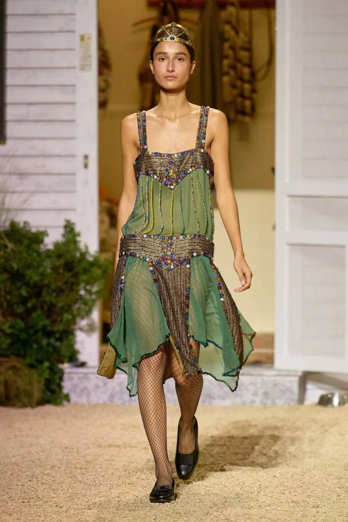 Un model într-o rochie fără bretele verde și auriu