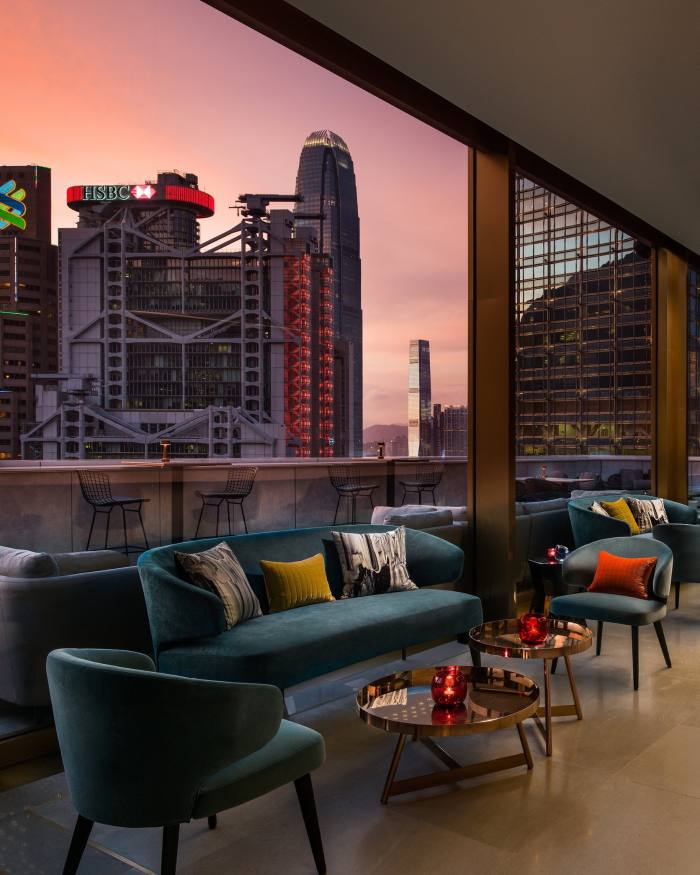 Terasa lui Popinjays, cu canapele și scaune din catifea turcoaz, cu vedere spre clădirea HSBC