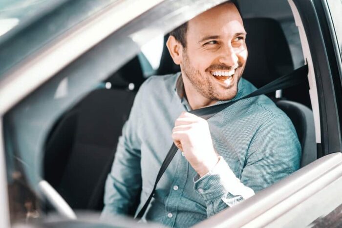 Portrait,Of,Smiling,Caucasian,Man,Fastening,Seat,Belt,And,Sitting