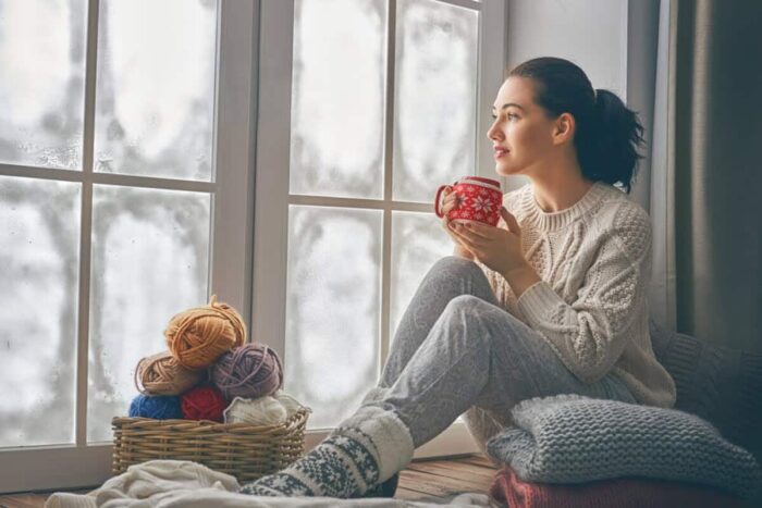 Beautiful,Young,Woman,Sitting,By,The,Window,And,Looking,At