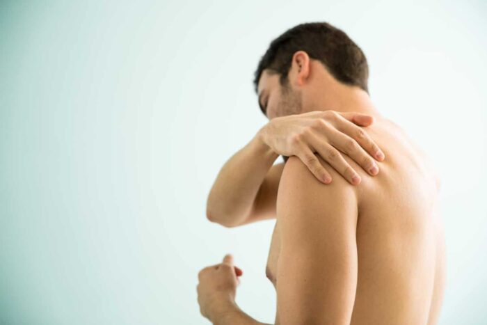 shirtless-young-man-suffering-from-muscle-pain-his-shoulder-visiting-spa-relieve-it