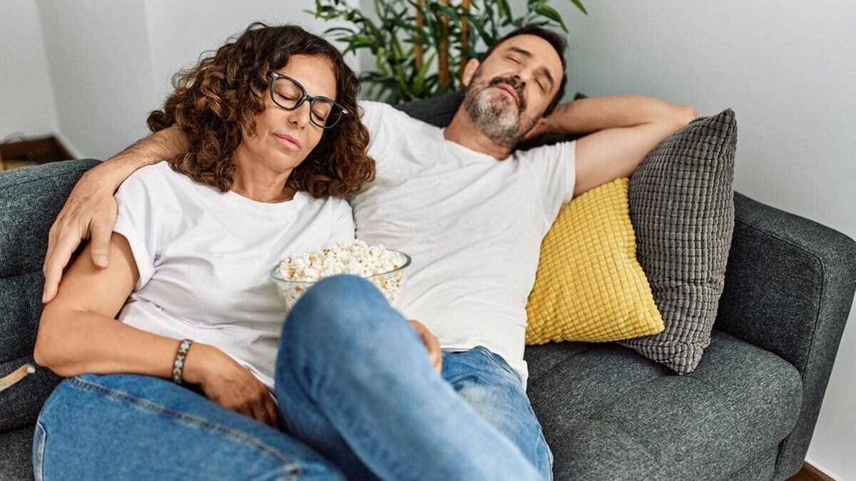 Middle,Age,Hispanic,Couple,Sleeping,Sitting,On,The,Sofa,At