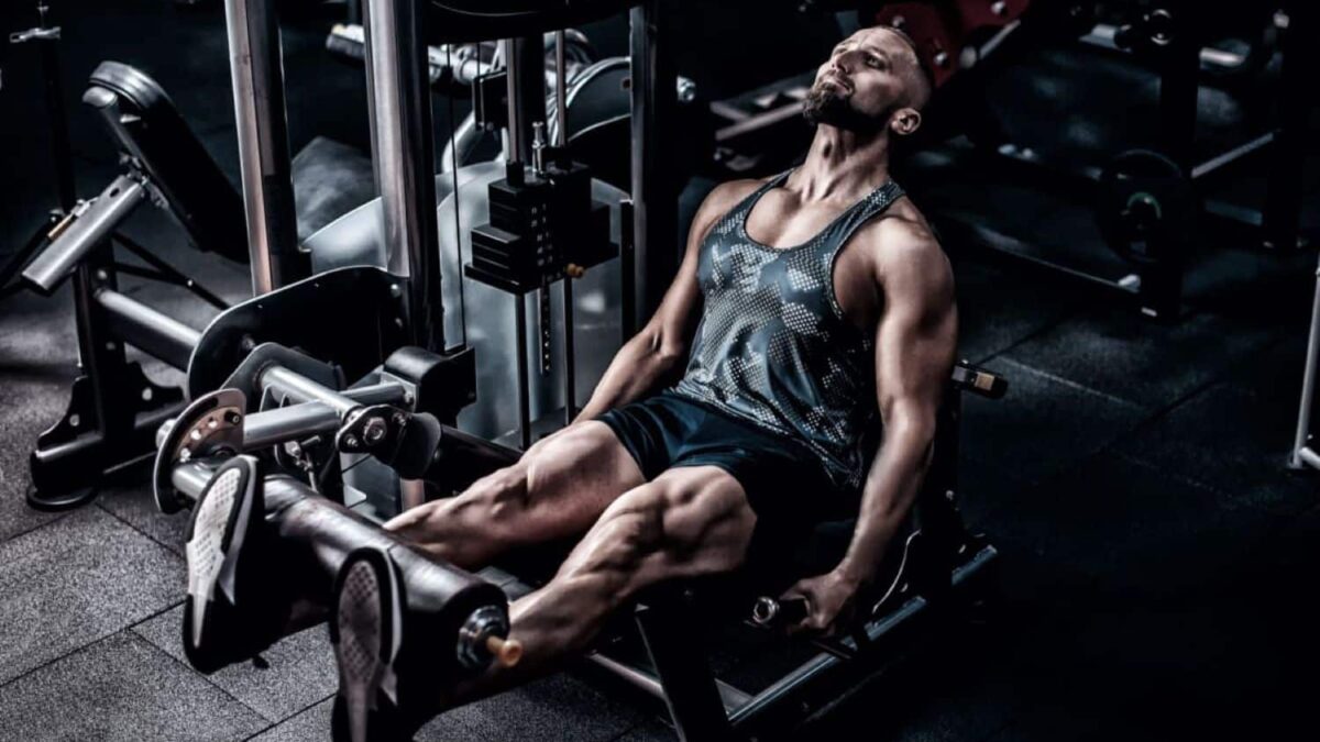 muscular athlete using weight machine for legs at the gym 1