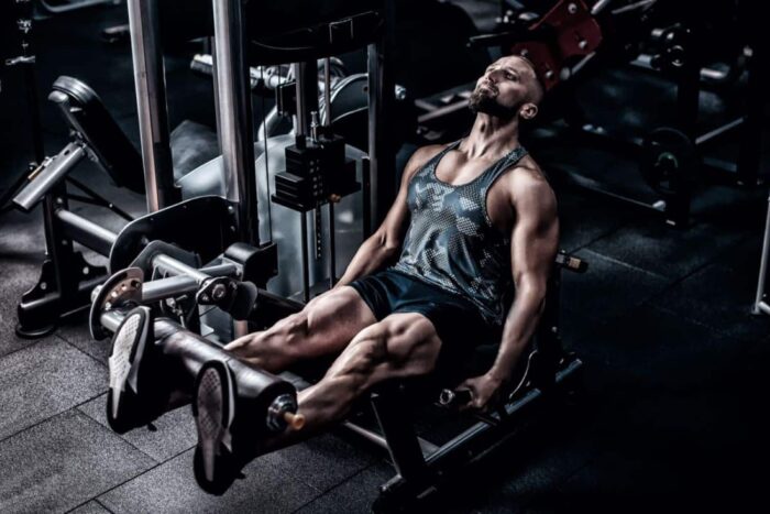 muscular-athlete-using-weight-machine-for-legs-at-the-gym (1)