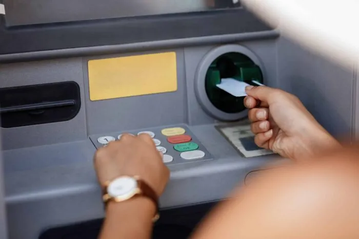closeup-woman-typing-pin-code-while-withdrawing-money-from-atm-scaled.jpg