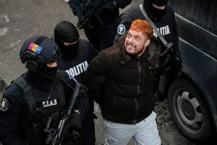 ofiteri-de-politie-il-escorteaza-pe-mohamed-amra-23-februarie-2025-dupa-arestarea-sa-cu-o-zi-inainte.jpeg