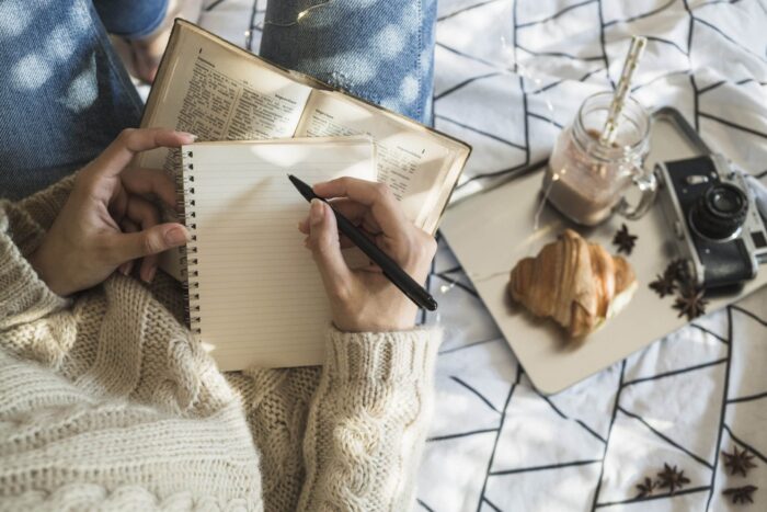 crop-woman-making-notes-near-camera-breakfast-food-scaled.jpg