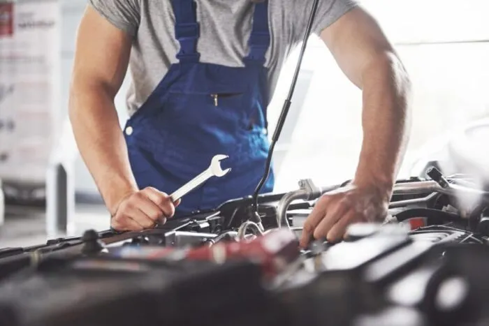 muscular-car-service-worker-repairing-vehicle-1024x684.jpg