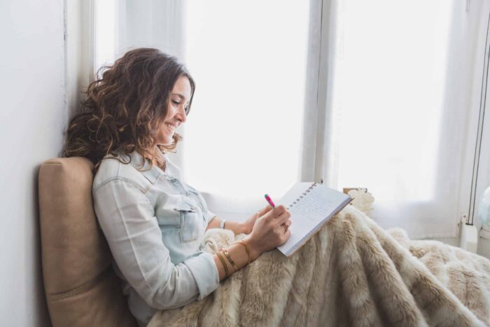 relaxed young woman writing her notebook scaled