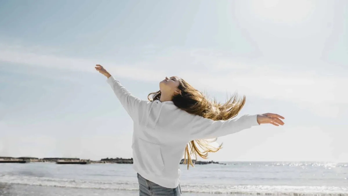 young-woman-enjoying-ocean-breeze-scaled.jpg