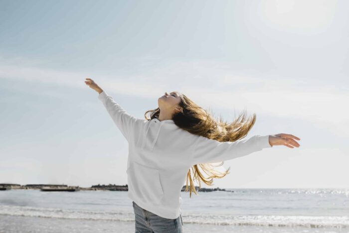 young woman enjoying ocean breeze scaled