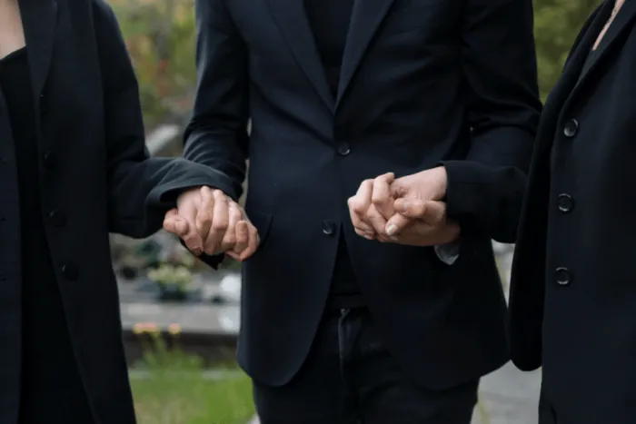 familie-indoliata-care-se-tine-de-mana-petru-funerare.png