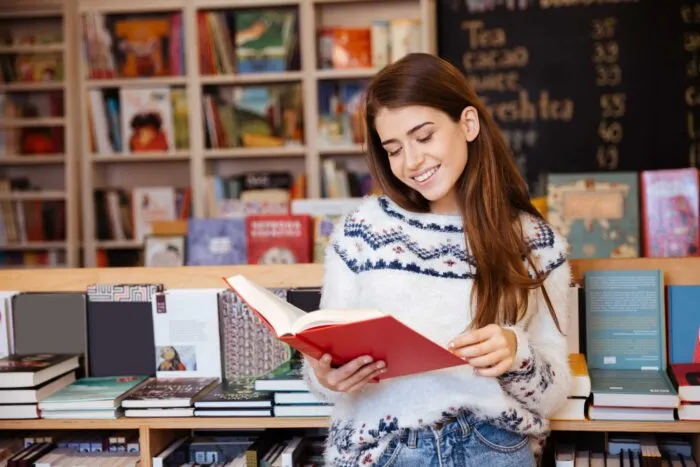 Portrait,Of,A,Pretty,Smiling,Girl,Reading,Book,Indoors,In