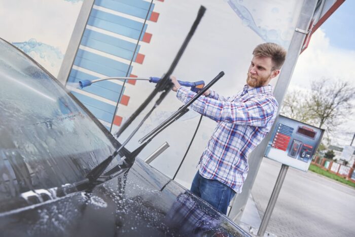 man cleaning his car self service
