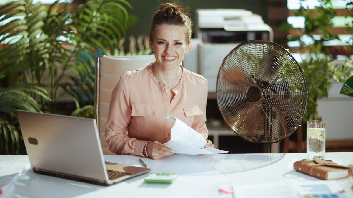 Portrait of happy modern woman worker in modern green office