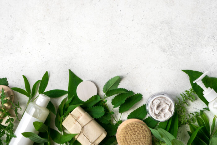 Natural,Cosmetics,And,Green,Leaves,On,White,Stone,Background,,Copy