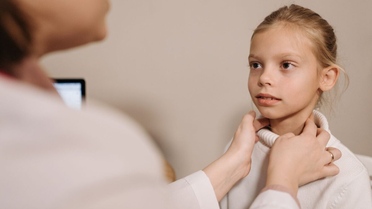 Medic examinand gatul unei fetite
