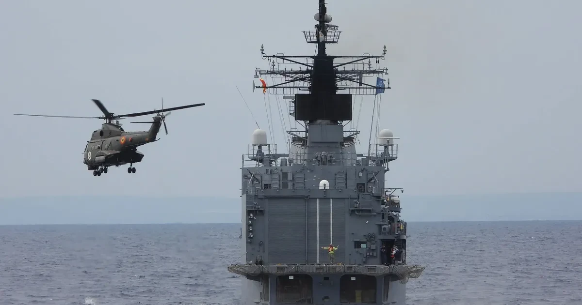 Elicopter militar lângă navă de război