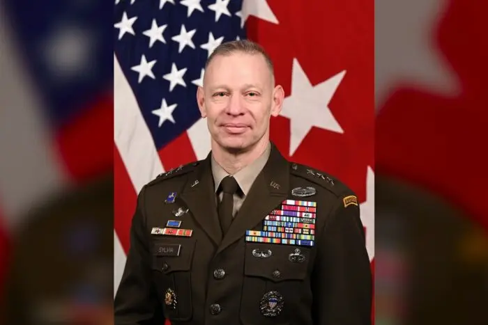 Un portret oficial de tip bust al generalului-locotenent american Brett Sylvia, purtând uniforma militară de ceremonie cu numeroase decorații și însemne de rang