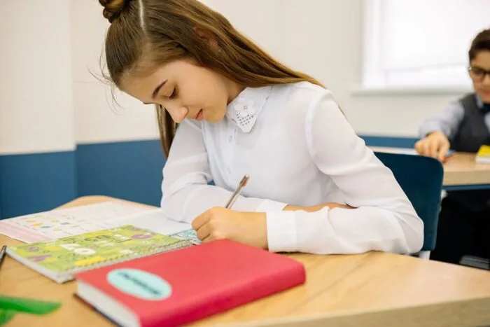 Elevă care participă la activități școlare într-o sală de clasă