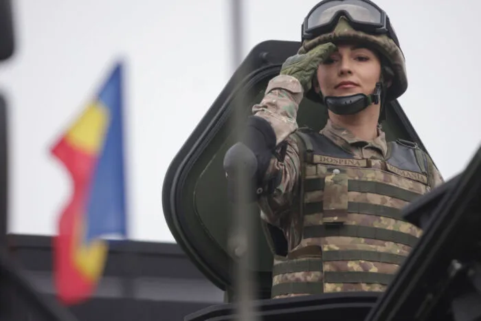 Militar român salutând dintr-un vehicul de luptă în timpul unei parade