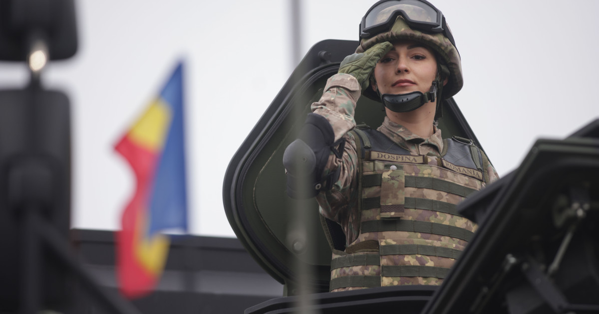 Militar român salutând dintr-un vehicul de luptă în timpul unei parade