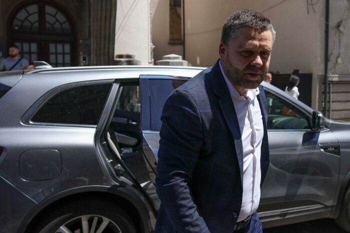 Un reprezentant politic în fața unei clădiri de locuințe din oraș