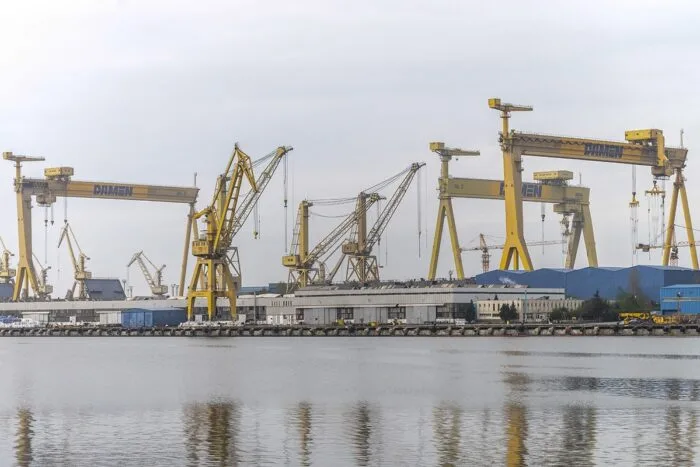 Vedere de ansamblu a utilajelor dintr-un șantier naval de la malul mării