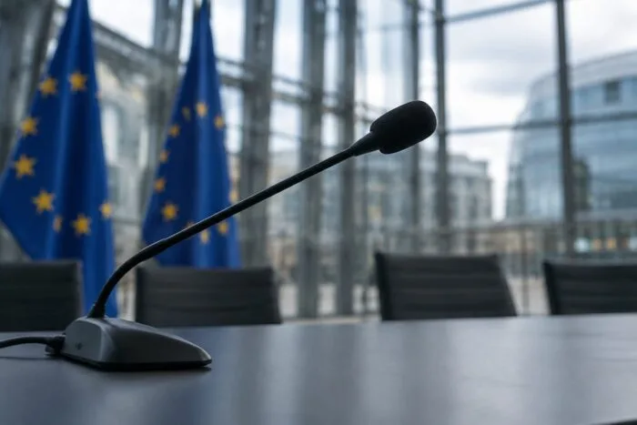 Microfon de conferință și steaguri europene în sala de presă