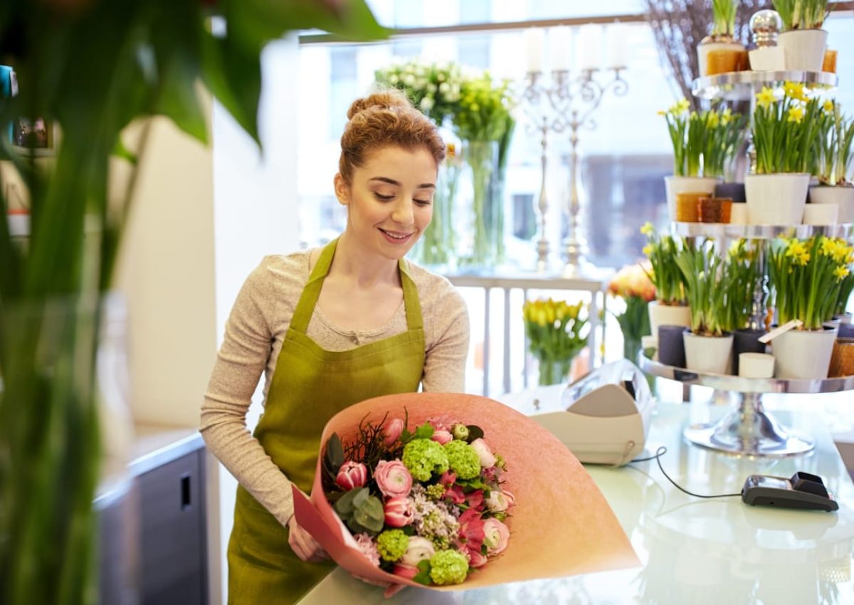 people-business-sale-floristry-concept-happy-smiling-florist-woman-wrapping-bunch-into-paper-flower-shop